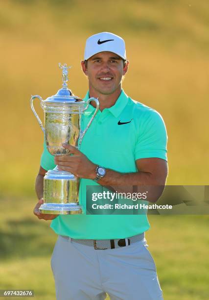 Brooks Koepka of the United States poses with the winner's trophy after his victory at the 2017 U.S. Open at Erin Hills on June 18, 2017 in Hartford,...