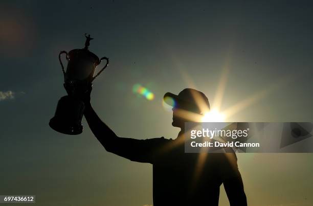 Brooks Koepka of the United States holds the U.S.Open trophy after his four shot win in the final round of the 117th US Open Championship at Erin...