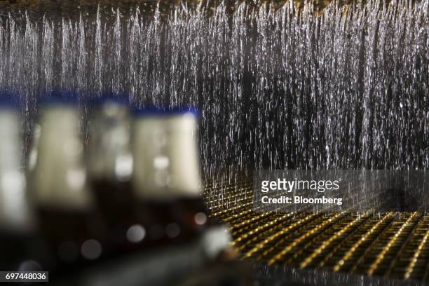 Falling water washes bottles of non-alcoholic strawberry flavored malt at the Murree Brewery Co. Factory in Rawalpindi, Punjab, Pakistan, on...