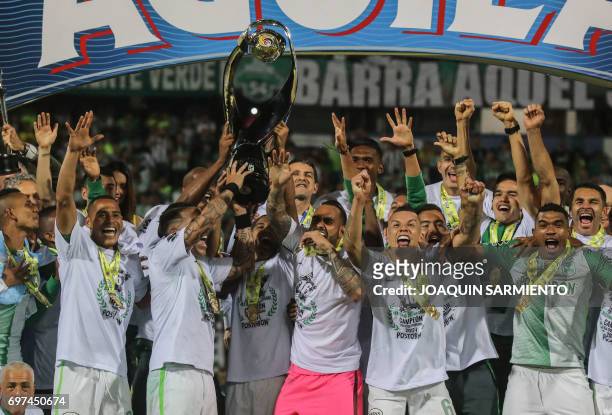 Players of Atletico Nacional celebrate with the trophy after winning the Colombian Apertura football league tournament by defeating Deportivo Cali...