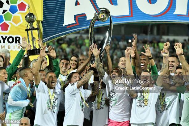 Dayro Moreno of Atletico Nacional lifts the trophy with teammates to celebrate after winning the Final second leg match between Atletico Nacional and...