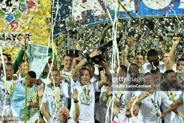 Dayro Moreno of Atletico Nacional lifts the trophy with teammates to celebrate after winning the Final second leg match between Atletico Nacional and...