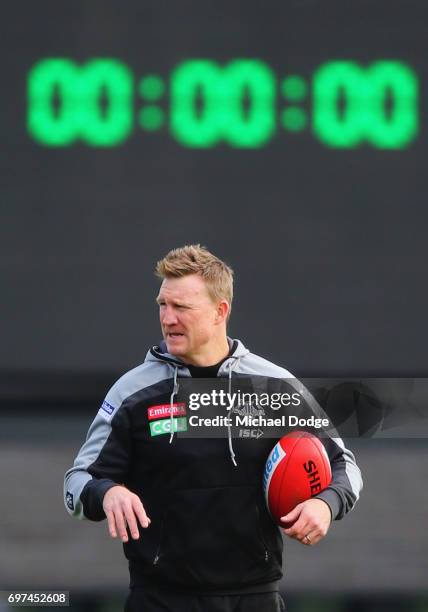 Magpies head coach Nathan Buckley looks upfield with the time clock behind him during a Collingwood Magpies AFL training session at Gosch's Paddock...