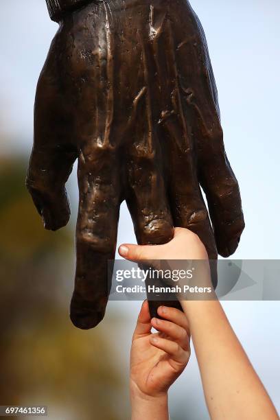 Children hold the hand of a new statue of former All Blacks player Sir Colin Meads on June 19, 2017 in Te Kuiti, New Zealand. The 1.5 x life size...