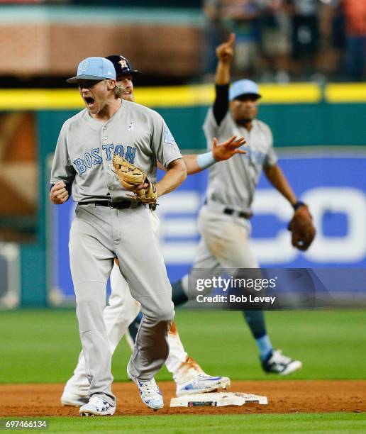 Josh Rutledge of the Boston Red Sox celebrates after tagging out Derek Fisher of the Houston Astros trying to steal second base in the ninth inning...