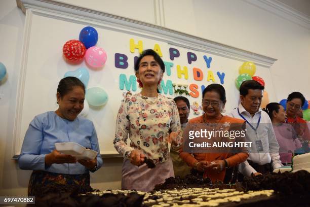 Myanmar's State Counsellor Aung San Suu Kyi distributes cake as she celebrates her 72nd birthday at the parliament building in Naypyidaw on June 19,...