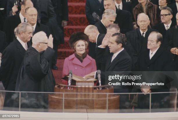 Recently elected 37th President of the United States, Richard Nixon being administered the presidential oath of office by Chief Justice Earl Warren...