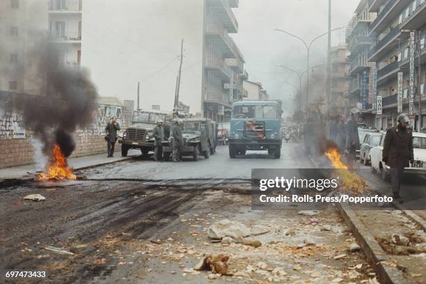 View of policemen patrolling a street with burning barricades in the Sbarre district of Reggio Calabria following a period of rioting by residents,...