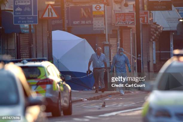 Police forensics officer walks from the scene where a van is believed to be involved in an incident near Finsbury Park Mosque in which the van...