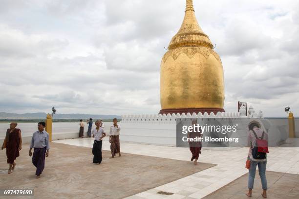 Visitors and tourists walk in front of the Bupaya Pagoda in Bagan, Myanmar, on Saturday, June 10, 2017. When the country opened to the outside world...