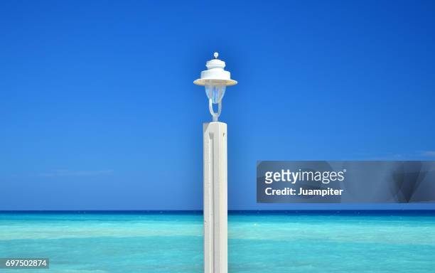 una farola frente al mar en la playa de altea. alicante - farola stock pictures, royalty-free photos & images