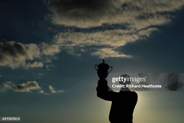 Brooks Koepka of the United States poses with the winner's trophy after his victory at the 2017 U.S. Open at Erin Hills on June 18, 2017 in Hartford,...