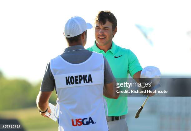 Brooks Koepka of the United States and caddie Richard Elliott react after finishing on the 18th green during the final round of the 2017 U.S. Open at...