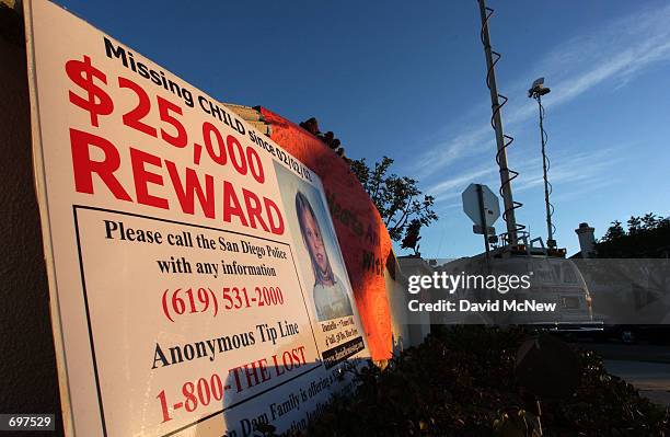 Reward poster near television news trucks advertises the newly increased $25,000 reward from the van Dam familys personal funds in the hopes of...