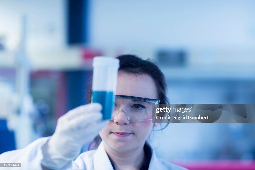 Young female scientist examining test tube in a laboratory, Freiburg Im Breisgau, Baden-wuerttemberg, Germany