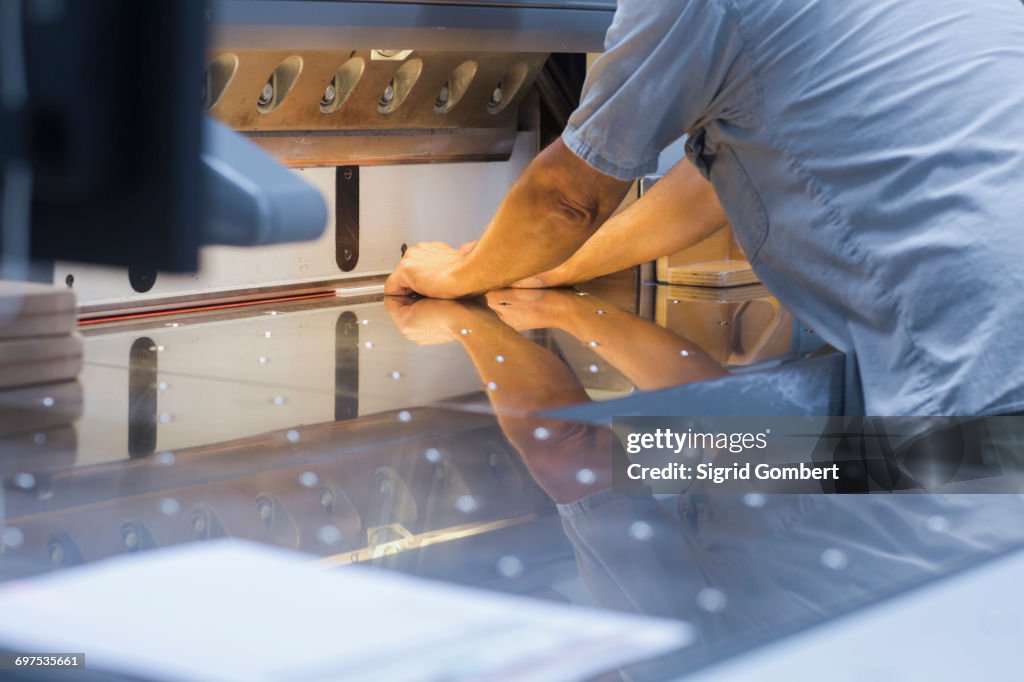 Mature man working in books printing industry, Bremgarten, Hartheim am Rhein, Baden-Wuerttemberg, Germany