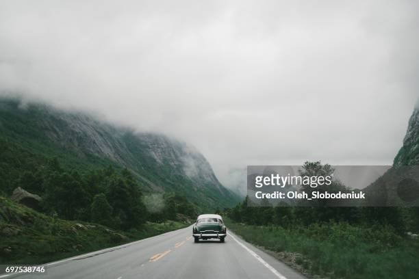 old-fashioned car on the winding road in mountains in norway - archival car stock pictures, royalty-free photos & images