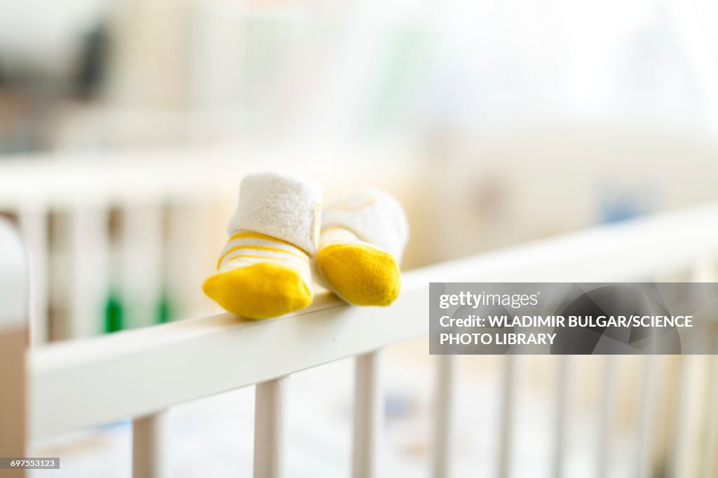 Baby booties on the edge of a cot