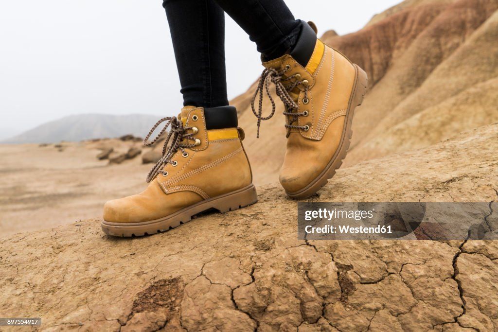 Spain, Navarra, Bardenas Reales, hiking shoes of young woman in nature park, close-up