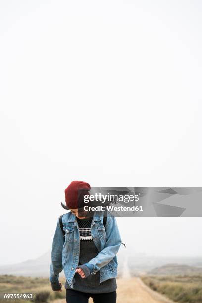 spain, navarra, bardenas reales, smiling young woman walking in nature park - bardenas photos et images de collection