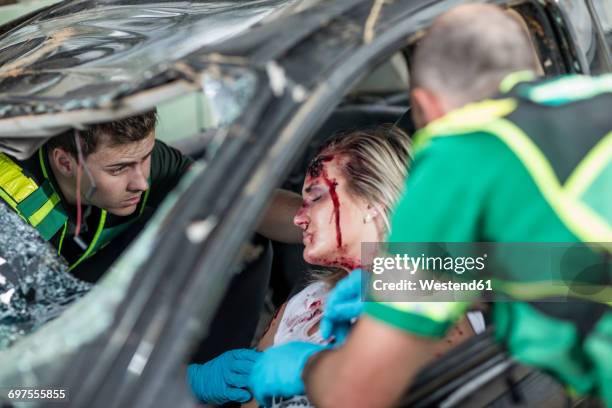 paramedics helping car crash victim after accident - gory car accident fotos stock-fotos und bilder