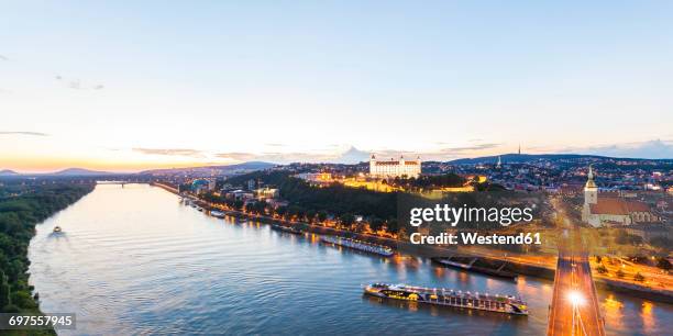 slovakia, bratislava, cityscape with river cruise ships on the danube at evening twilight - danube river foto e immagini stock