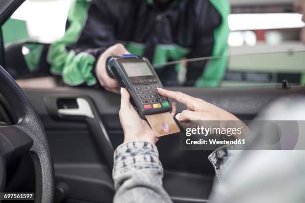 female customer paying with credit card at the fuel station - petrol paying stock-fotos und bilder