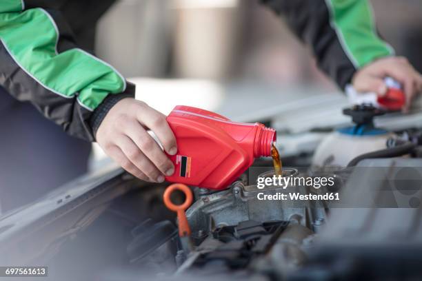 man filling up car with motor oil - ölwechsel stock-fotos und bilder