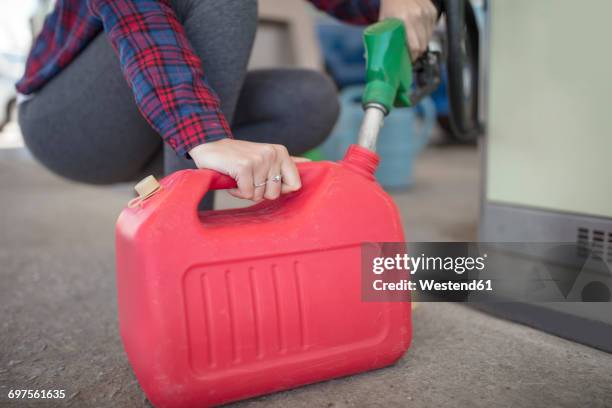 woman filling up canister at fuel station - canister stock-fotos und bilder