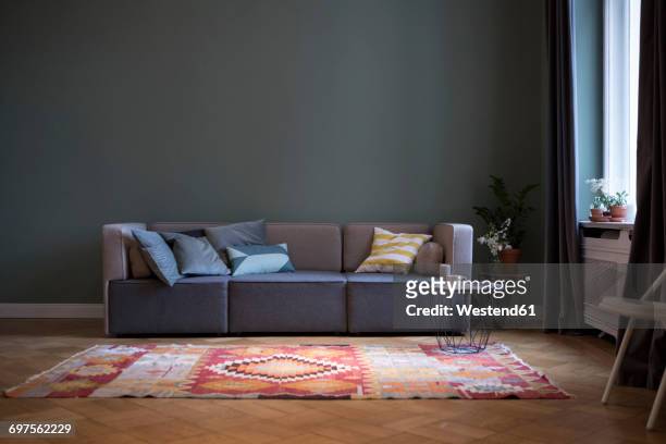 living room with couch and carpet - sofa stock-fotos und bilder