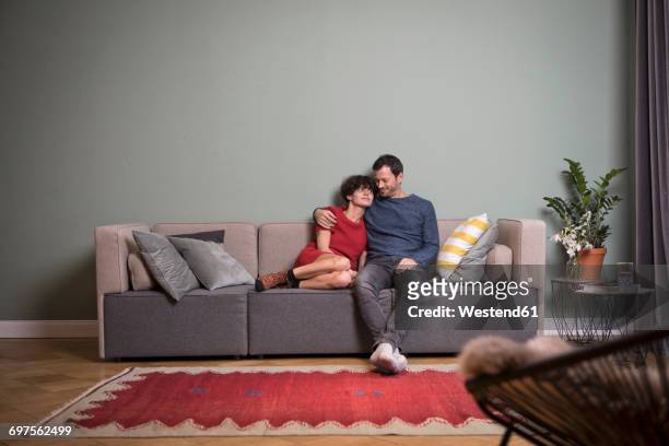 couple sitting together on the couch - film still stock-fotos und bilder
