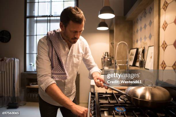 man cooking at home - apartment fire stock pictures, royalty-free photos & images