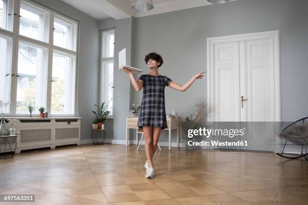 young woman with laptop at home - standing with laptop imagens e fotografias de stock