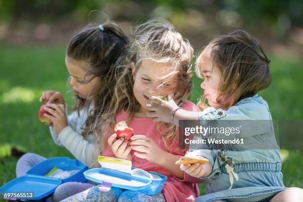 girls in garden sharing lunch - jause stock-fotos und bilder