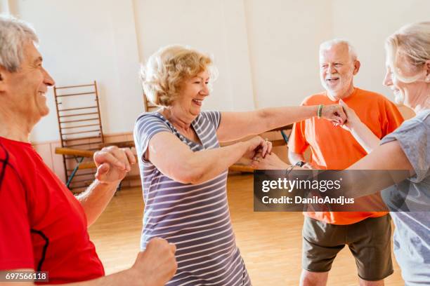 alegre grupo de práctica de la tercera edad bailando juntos y divertirse - dance studio fotografías e imágenes de stock