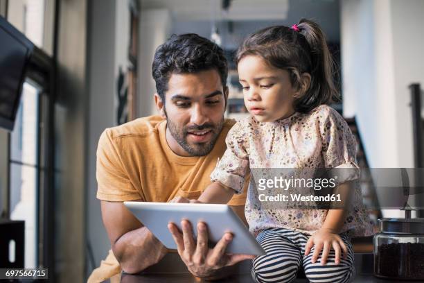 father and daughter using digital tablet - monoparental fotografías e imágenes de stock