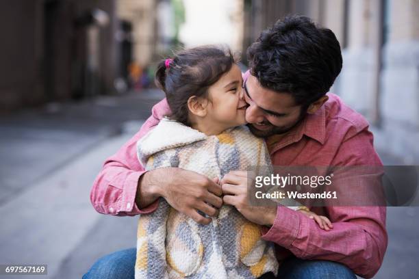 father dressing daughter in warm coat - kids dressing up stock-fotos und bilder