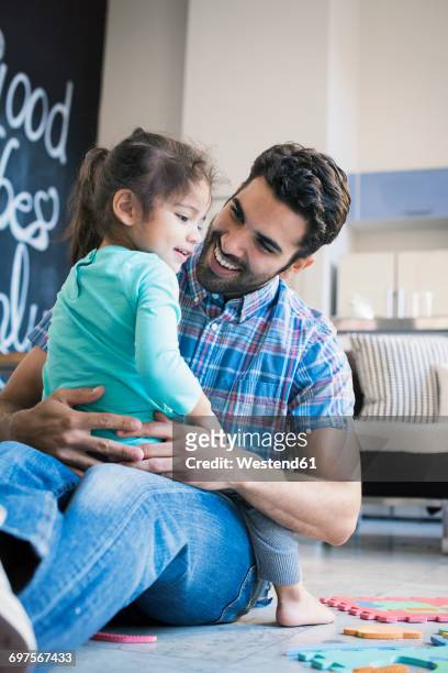 father and daughter sitting on floor playing with children's puzzle - 2 3 anni foto e immagini stock