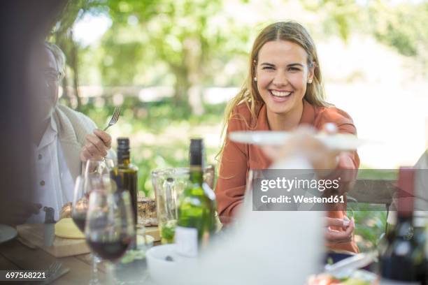 smiling woman at family lunch in garden - plate eating table imagens e fotografias de stock