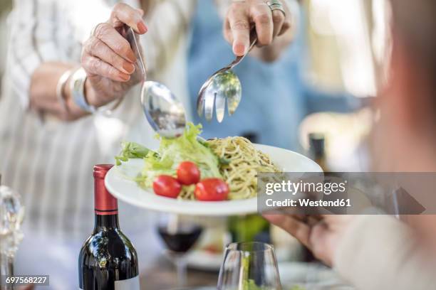 dishing up salad and spaghetti for lunch in garden - eating pesto stock pictures, royalty-free photos & images