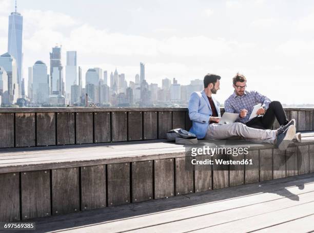 usa, two businessmen working at new jersey waterfront with view to manhattan - waterfront living stock pictures, royalty-free photos & images
