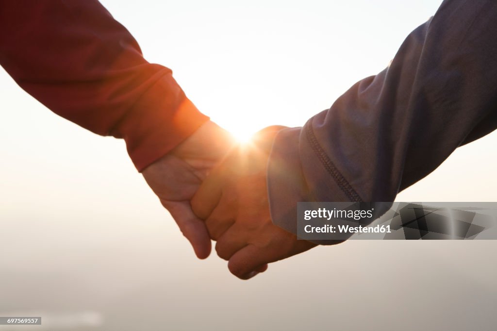 Couple hand in hand at sunset