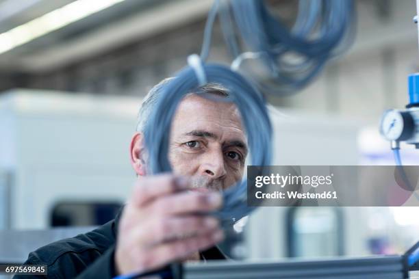 technician checking cables in factory - technician stock-fotos und bilder