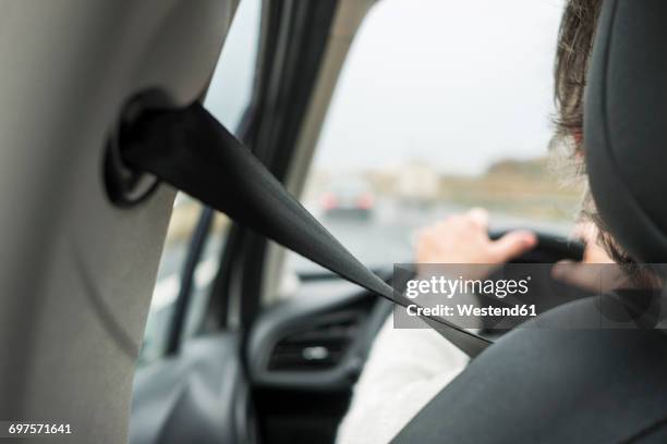 woman in car with safety belt - gürtel stock-fotos und bilder