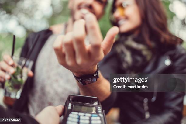 man at cafe paying contactless with smartwatch - smart watch on wrist stock pictures, royalty-free photos & images