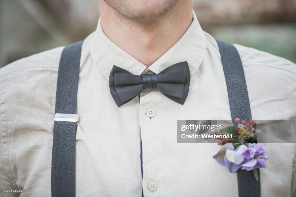 Close-up of groom wearing floral decoration