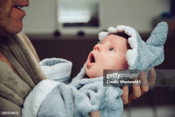 father holding baby wearing shark bathrobe - baby shark stock pictures, royalty-free photos & images