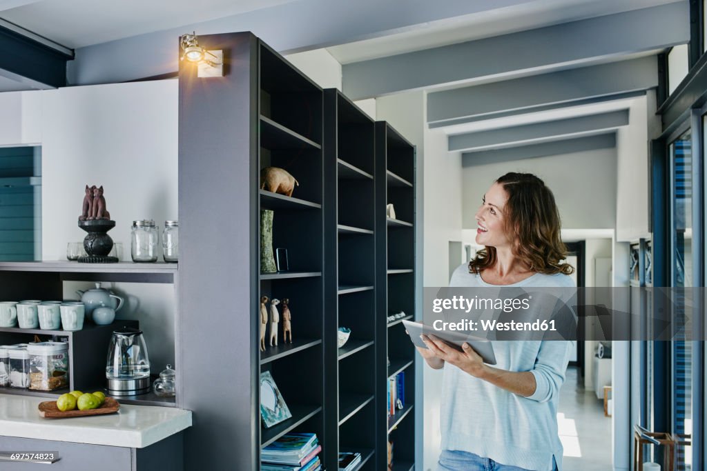 Woman regulating lamp with digital tablet