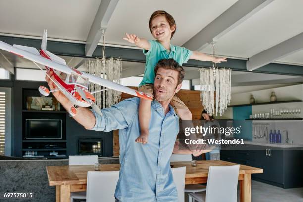 father and son playing with toy airplane - flying dad son stock pictures, royalty-free photos & images