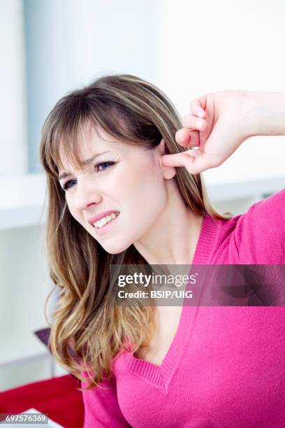 ear pain in a woman - woman fingers in ears fotografías e imágenes de stock